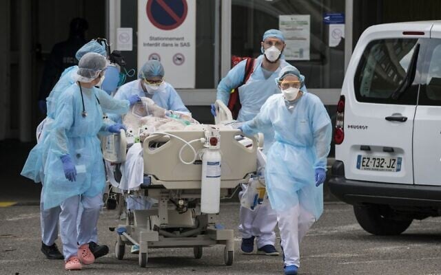 Medical staff use a trolley to move a patient toward a medical helicopter at The Emile Muller Hospital in Mulhouse, eastern France, on March 22, 2020, as patients are evacuated to another hospital facility, on the sixth day of a strict lockdown in France to stop the spread of COVID-19. (SEBASTIEN BOZON / AFP) Medical staff use a trolley to move a patient toward a medical helicopter at The Emile Muller Hospital in Mulhouse, eastern France, on March 22, 2020, as patients are evacuated to another hospital facility, on the sixth day of a strict lockdown in France to stop the spread of COVID-19. (SEBASTIEN BOZON / AFP)