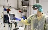 Illustrative: A doctor checks a medical ventilator control panel while wearing protective clothing at the Samson Assuta Ashdod University Hospital, March 16, 2020. (Jack Guez/AFP)