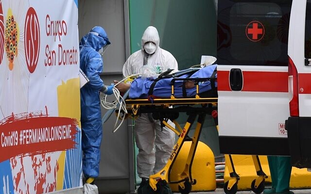 Medical workers stretcher a patient from an Italian Red Cross ambulance into an intensive care unit set up in a sports center outside the San Raffaele hospital in Milan, during the coronavirus pandemic, March 23, 2020. (Miguel MEDINA/AFP) Medical workers stretcher a patient from an Italian Red Cross ambulance into an intensive care unit set up in a sports center outside the San Raffaele hospital in Milan, during the coronavirus pandemic, March 23, 2020. (Miguel MEDINA/AFP)