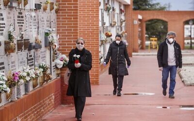 People wearing face masks arrive at the South Municipal cemetery in Madrid, to attend the burial of a man who died of the new coronavirus, on March 23, 2020. (BALDESCA SAMPER/AFP)