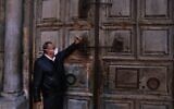 Adeeb Joude, the custodian in charge of the ancient key to the Church of the Holy Sepulchre, closes the entrance gate to the church due to the coronavirus (COVID-19) pandemic, in Jerusalem's Old City on March 25, 2020. (Ahmad GHARABLI / AFP)