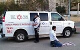 This handout photo provided by the Magen David Adom (MDA) national emergency service on March 24, 2020, in Beersheba shows two paramedics praying outside an ambulance of the American Friends of Magen David Adom (AFMDA): a Jew from Beersheba facing Jerusalem, and an Arab from Rahat facing Mecca (MAGEN DAVID ADOM)