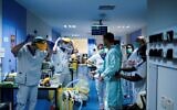 Illustrative: Medical workers put on their protective gears before working on March 27, 2020, at the unit for coronavirus COVID-19 infected patients at the Erasme Hospital in Brussels. (Photo by Kenzo TRIBOUILLARD / AFP)