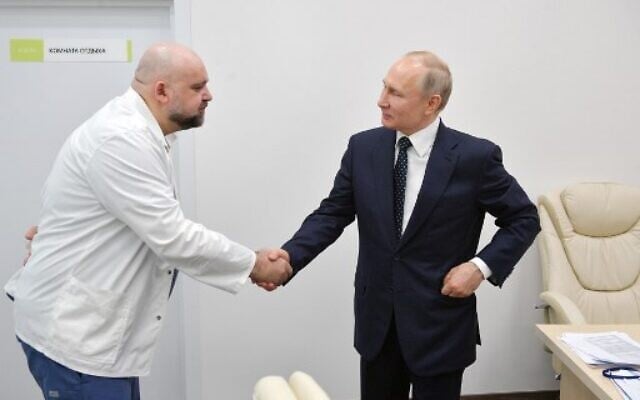 A picture taken on March 24, 2020 shows Russian President Vladimir Putin, right, shaking hands with the head of Moscow's new hospital treating coronavirus (COVID-19) patients, Denis Protsenko, during his visit to Kommunarka hospital in Moscow. (Alexey DRUZHININ / SPUTNIK / AFP) A picture taken on March 24, 2020 shows Russian President Vladimir Putin, right, shaking hands with the head of Moscow's new hospital treating coronavirus (COVID-19) patients, Denis Protsenko, during his visit to Kommunarka hospital in Moscow. (Alexey DRUZHININ / SPUTNIK / AFP)