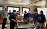 Jacob Margolis, front left, was joined by his sister Sophie, his parents Elana and Ariel, and other volunteers who donned protective masks and gloves in the kitchen of The Chubby Chickpea, a food truck company in Boston owned by Avi Shemtov, to prep sandwiches to give to school kids and others in Sharon, Massachusetts. (Courtesy of Neil Morris/ via JTA)