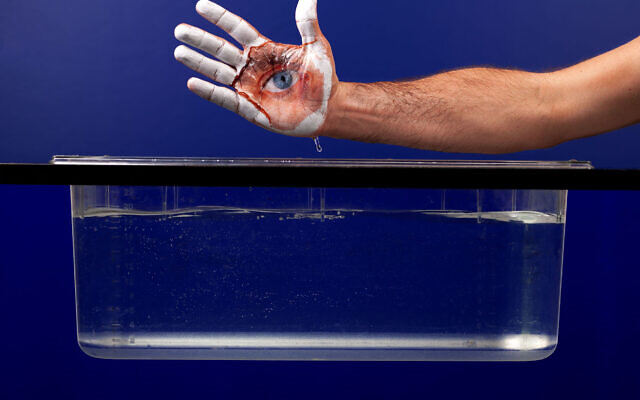 Guy Aon showing his photo developing technology that allows him to place photos on the body, in a kind of flexible body mask (Courtesy Guy Aon)