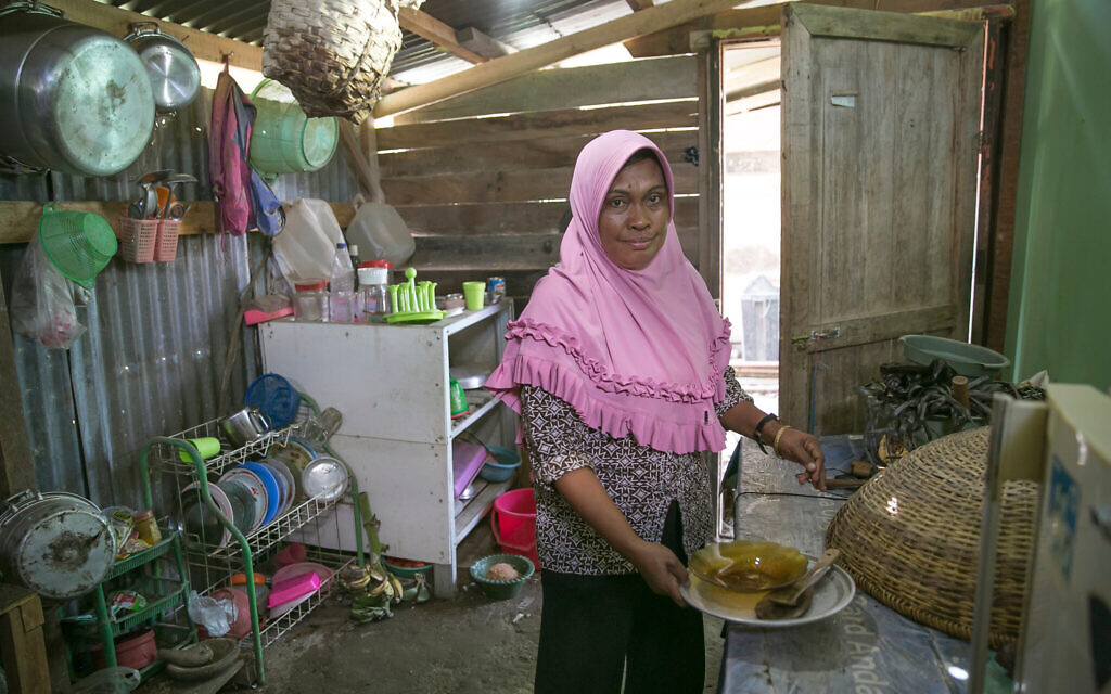 A woman cooks in a community kitchen in a DP camp outside Palu, Indonesia. With little access to medical care and living in cramped, temporary housing, her community is at high risk for COVID-19. (Allison Joyce/AJWS)