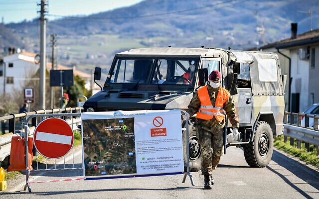 An Italian army soldier blocks off a road leading to the village of Vo'Euganeo, in Italy's northern Veneto region, on February 28, 2020. (Claudio Fulan/LaPresse via AP) An Italian army soldier blocks off a road leading to the village of Vo'Euganeo, in Italy's northern Veneto region, on February 28, 2020. (Claudio Fulan/LaPresse via AP)