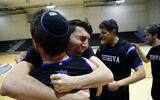 Yeshiva forward Michael Bixon hugs forward Daniel Katz, back to camera, after the team's 102-83 win over Penn State-Harrisburg in the second round of the NCAA men's Division III college basketball tournament, March 7, 2020, in Baltimore. (AP Photo/Jessie Wardarski)
