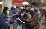Police officers and soldiers check passengers leaving from Milan main train station, Italy, Monday, March 9, 2020. (AP Photo/Antonio Calanni)