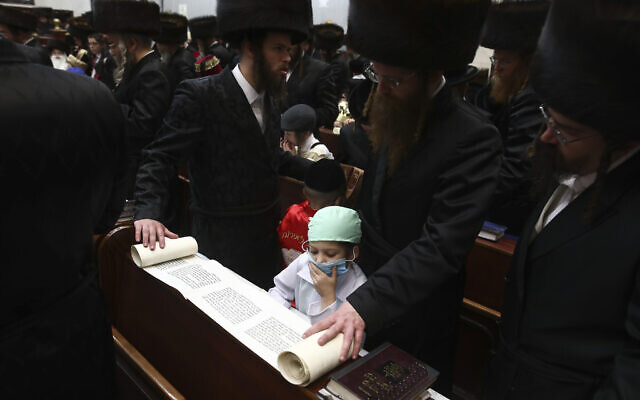 Ultra Orthodox Jewish boy wears a doctor's costume during the first day of a Purim holiday as the Book of Esther is read in a synagogue in Bnei Brak, Israel, Monday, March 9, 2020. (AP Photo/Oded Balilty)