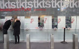 Empty ticket selling booths are seen as a couple buys discounted Broadway theater tickets at the TKTS kiosk, March 11, 2020, in New York's Times Square. (AP Photo/Mary Altaffer)