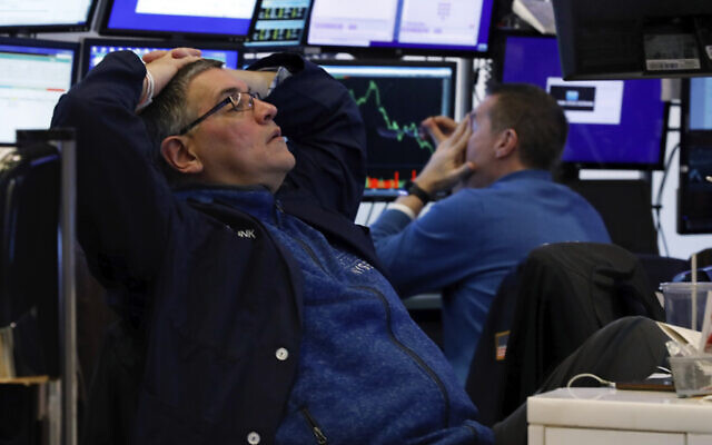 A pair of traders work in their booth on the floor of the New York Stock Exchange, Thursday, March 12, 2020. The deepening coronavirus crisis is sending stocks into another alarming slide on Wall Street, triggering a brief, automatic shutdown in trading for the second time this week. (AP Photo/Richard Drew) A pair of traders work in their booth on the floor of the New York Stock Exchange, Thursday, March 12, 2020. The deepening coronavirus crisis is sending stocks into another alarming slide on Wall Street, triggering a brief, automatic shutdown in trading for the second time this week. (AP Photo/Richard Drew)