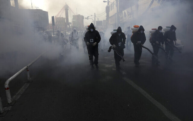 Firefighters disinfect a street against the new coronavirus, in western Tehran, Iran, March 13, 2020. (Vahid Salemi/AP) Firefighters disinfect a street against the new coronavirus, in western Tehran, Iran, March 13, 2020. (Vahid Salemi/AP)