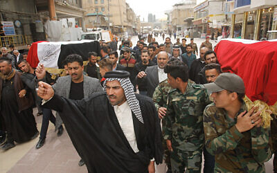 Mourners carry the flag-draped coffins of two fighters of the Popular Mobilization Forces who were killed during US attacks in Iraq, during their funeral procession at the Imam Ali shrine in Najaf, Iraq, March 14, 2020. (AP Photo/Anmar Khalil)