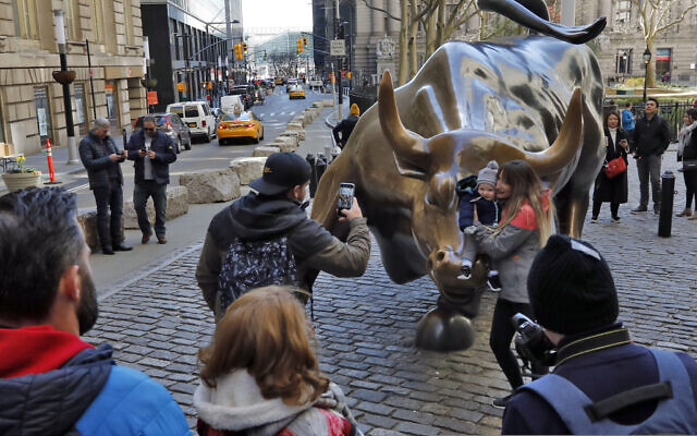 People pose for photos with the Charging Bull statue in New York's Financial District, Sunday, March 15, 2020. (AP Photo/Richard Drew) People pose for photos with the Charging Bull statue in New York's Financial District, Sunday, March 15, 2020. (AP Photo/Richard Drew)