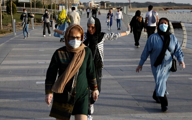 People wearing face masks exercise on the shore of an artificial lake, in Western Tehran, Iran, March 15, 2020. (Vahid Salemi/AP) People wearing face masks exercise on the shore of an artificial lake, in Western Tehran, Iran, March 15, 2020. (Vahid Salemi/AP)