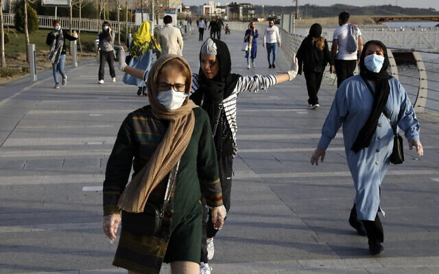 People wearing face masks exercise on the shore of an artificial lake in western Tehran, Iran, March 15, 2020. (AP Photo/Vahid Salemi) People wearing face masks exercise on the shore of an artificial lake in western Tehran, Iran, March 15, 2020. (AP Photo/Vahid Salemi)