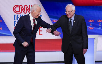 Former Vice President Joe Biden, left, and Sen. Bernie Sanders, I-Vt., right, greet one another before they participate in a Democratic presidential primary debate at CNN Studios in Washington, March 15, 2020. (AP/Evan Vucci)