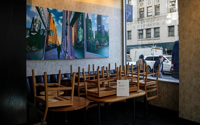 Chairs are stacked in a Starbucks coffee shop that remained open for customers purchasing for take-away, in New York, March 16, 2020. (John Minchillo/AP) Chairs are stacked in a Starbucks coffee shop that remained open for customers purchasing for take-away, in New York, March 16, 2020. (John Minchillo/AP)