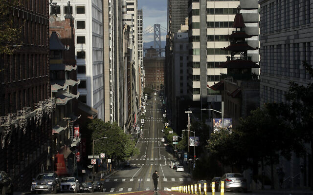 A man stands in the middle of cable car tracks on a near empty California Street in San Francisco, Saturday, March 21, 2020. (AP Photo/Jeff Chiu) A man stands in the middle of cable car tracks on a near empty California Street in San Francisco, Saturday, March 21, 2020. (AP Photo/Jeff Chiu)