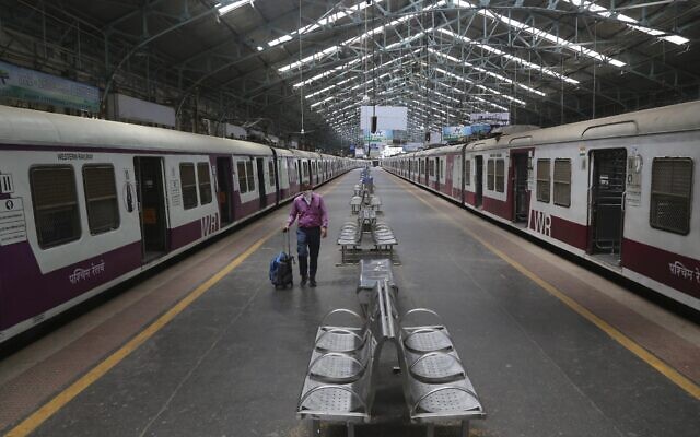 A man wearing a mask walks through a deserted train station in Mumbai, India, Sunday, March 22, 2020. (AP Photo/Rafiq Maqbool) A man wearing a mask walks through a deserted train station in Mumbai, India, Sunday, March 22, 2020. (AP Photo/Rafiq Maqbool)
