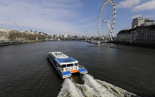 An empty tour boat on the River Thames in central London, with the London Eye wheel at right, Sunday, March 22, 2020. (AP Photo/Kirsty Wigglesworth) An empty tour boat on the River Thames in central London, with the London Eye wheel at right, Sunday, March 22, 2020. (AP Photo/Kirsty Wigglesworth)