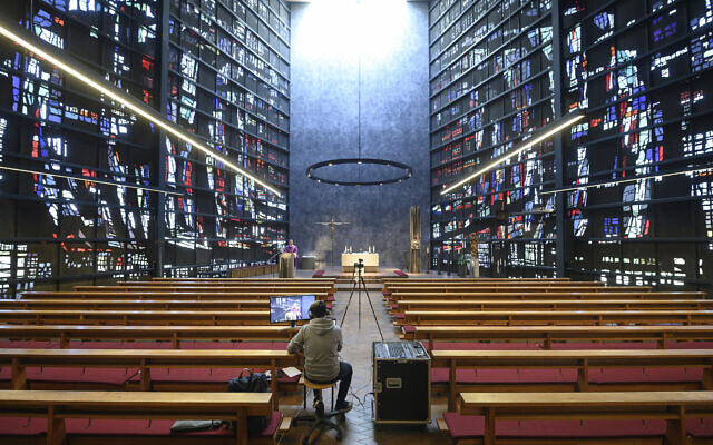 Parish vicar Patrick Stauss conducts a service of the Catholic parish of the Assumption of Mary via YouYube in an empty church in Winterbach, Germany, Sunday, March 22, 2020. (Sebastian Gollnow/dpa via AP) Parish vicar Patrick Stauss conducts a service of the Catholic parish of the Assumption of Mary via YouYube in an empty church in Winterbach, Germany, Sunday, March 22, 2020. (Sebastian Gollnow/dpa via AP)