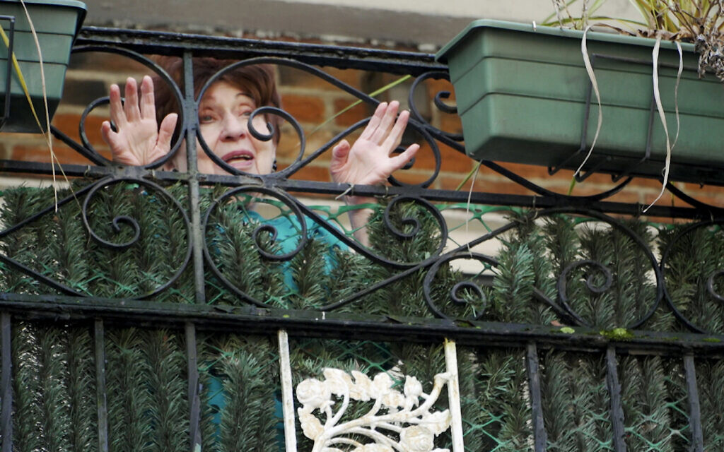 Holocaust survivor Alice Rosenberg speaks to meal delivery volunteer Freida Rothman from her balcony in Brooklyn, New York, March 19, 2020. (AP Photo/Jessie Wardarski)
