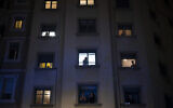 People applaud from their window in support of the medical staff working on the COVID-19 virus outbreak in Barcelona, Spain, Monday, March 23, 2020.  (AP Photo/Felipe Dana)