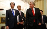 US Treasury Secretary Steven Mnuchin, left, accompanied by White House Legislative Affairs Director Eric Ueland and acting White House chief of staff Mark Meadows, speaks with reporters as he walks to the offices of Senate Majority Leader Mitch McConnell on Capitol Hill in Washington, March 24, 2020. (AP Photo/Patrick Semansky)