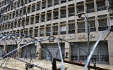 A worker walks outside the Lebanese Central Bank that has been shut down as part of the preventive measures against the coronavirus, in Beirut, Lebanon, March 18, 2020. (Bilal Hussein/AP)