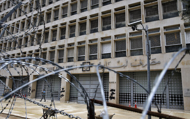 A worker walks outside the Lebanese Central Bank that has been shut down as part of the preventive measures against the coronavirus, in Beirut, Lebanon, March 18, 2020. (Bilal Hussein/AP) A worker walks outside the Lebanese Central Bank that has been shut down as part of the preventive measures against the coronavirus, in Beirut, Lebanon, March 18, 2020. (Bilal Hussein/AP)