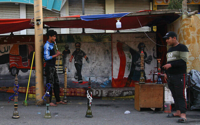 In this Thursday, March 19, 2020 photo, a man smokes waterpipe at Tahrir square, Baghdad, Iraq (AP Photo/Khalid Mohammed) In this Thursday, March 19, 2020 photo, a man smokes waterpipe at Tahrir square, Baghdad, Iraq (AP Photo/Khalid Mohammed)