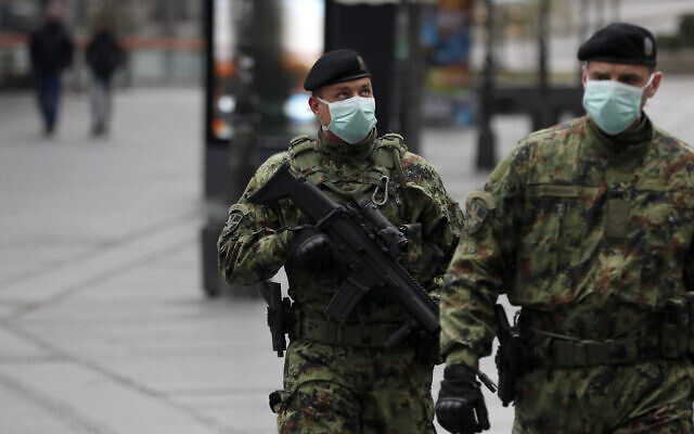 Serbian army soldiers patrol in Belgrade's main pedestrian street, in Serbia, March 26, 2020. (Darko Vojinovic/AP) Serbian army soldiers patrol in Belgrade's main pedestrian street, in Serbia, March 26, 2020. (Darko Vojinovic/AP)