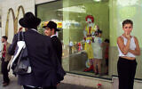 People stand outside a branch of  McDonald's in downtown Jerusalem in this file photo. The company has temporarily shut down its branches in Israel due to the coronavirus. (AP Photo/David Guttenfelder)