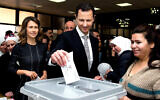 This photo from the official Facebook page of the Syrian Presidency shows Syrian President Bashar Assad casting his ballot in the parliamentary elections, as his wife Asma, left, stands next to him, in Damascus, Syria, April 13, 2016. (Syrian Presidency via AP, file)