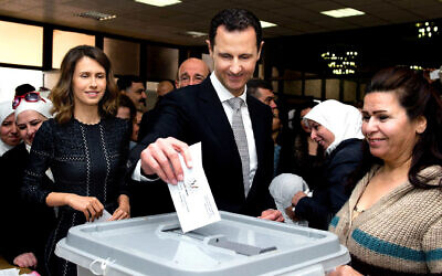 This photo from the official Facebook page of the Syrian Presidency shows Syrian President Bashar Assad casting his ballot in the parliamentary elections, as his wife Asma, left, stands next to him, in Damascus, Syria, April 13, 2016. (Syrian Presidency via AP, file)
