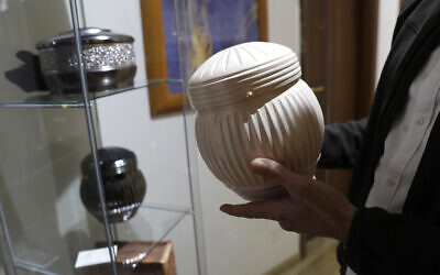 Illustrative: A man holds an urn at a cremation funeral parlor in Rome, October 25, 2016. (AP Photo/Alessandra Tarantino)