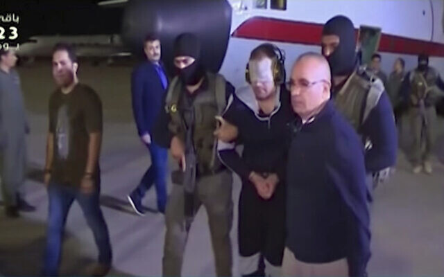 In this frame grab from Egyptian State Television, a blindfolded Hisham el-Ashmawi is escorted by Egyptian military officers and placed in a vehicle after being taken off a military plane at an airport in Cairo, Egypt, May 29, 2019 (Egyptian State Television via AP) In this frame grab from Egyptian State Television, a blindfolded Hisham el-Ashmawi is escorted by Egyptian military officers and placed in a vehicle after being taken off a military plane at an airport in Cairo, Egypt, May 29, 2019 (Egyptian State Television via AP)