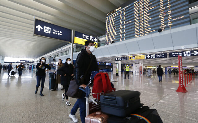 Illustrative: Passengers and airport staff wear masks at Rome's international airport, in Fiumicino, January 31, 2020. (Cecilia Fabiano/LaPresse via AP) Illustrative: Passengers and airport staff wear masks at Rome's international airport, in Fiumicino, January 31, 2020. (Cecilia Fabiano/LaPresse via AP)