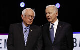 From left, Democratic US presidential candidates Bernie Sanders and Joe Biden, talk before a Democratic presidential primary debate, February 25, 2020, in Charleston, South Carolina. (AP Photo/Matt Rourke)