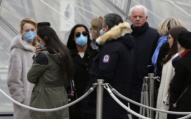Tourists, some wearing a mask, queue to enter the Louvre museum, in Paris, February 28, 2020. (Rafael Yaghobzadeh/AP) Tourists, some wearing a mask, queue to enter the Louvre museum, in Paris, February 28, 2020. (Rafael Yaghobzadeh/AP)