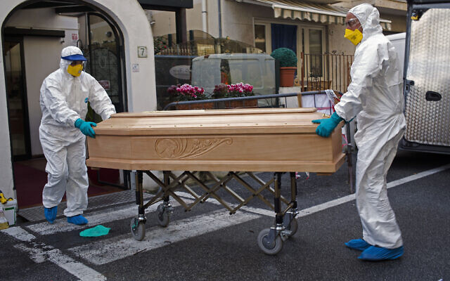 Medical staff wearing protective suits carry the coffin containing the body of a woman, 87, after she passed away in her room at the Garden hotel in Laigueglia, northwest Italy, Liguria region March 1, 2020. (AP Photo) Medical staff wearing protective suits carry the coffin containing the body of a woman, 87, after she passed away in her room at the Garden hotel in Laigueglia, northwest Italy, Liguria region March 1, 2020. (AP Photo)