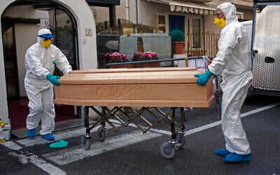 Medical staff wearing protective suits carry the coffin containing the body of Assunta Pastore, 87,who died after testing positive for the coronavirus at the Garden hotel in Laigueglia, northwest Italy, Liguria region, March 1, 2020. (AP Photo)