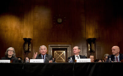 National Institute for Allergy and Infectious Diseases Director Dr. Anthony Fauci, second from left, accompanied by Centers for Disease Control and Prevention Principal Deputy Director Anne Schuchat, left, Health and Human Services Assistant Secretary for Preparedness and Response Dr. Robert Kadlec, second from right, and Food and Drug Administration Commissioner Dr. Stephen Hahn, right, testifies before a Senate Health, Education, Labor and Pensions Committee Hearing on the coronavirus on Capitol Hill, Tuesday, March 3, 2020, in Washington. (AP Photo/Andrew Harnik)