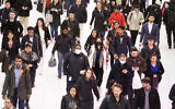 Three commuters, center, wear masks as they walk through the World Trade Center transportation hub, March 4, 2020, in New York. (AP Photo/Mark Lennihan)