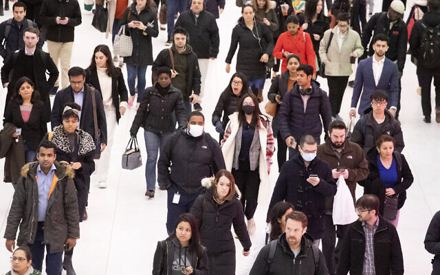Three commuters, center, wear masks as they walk through the World Trade Center transportation hub, March 4, 2020, in New York. (AP Photo/Mark Lennihan) Three commuters, center, wear masks as they walk through the World Trade Center transportation hub, March 4, 2020, in New York. (AP Photo/Mark Lennihan)