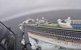 In this image from video, provided by the California National Guard, a helicopter carrying airmen with the 129th Rescue Wing flies over the Grand Princess cruise ship off the coast of California, March 5, 2020. (California National Guard via AP)