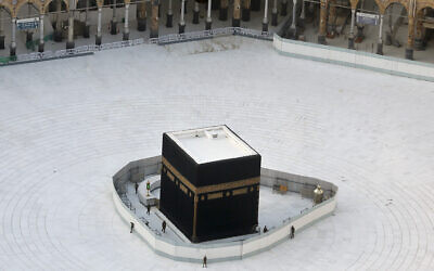 Saudi policemen guard the the Kaaba, the cubic building at the Grand Mosque, in the Muslim holy city of Mecca, Saudi Arabia, Friday, March 6, 2020, amid the coronavirus pandemic (AP Photo/Amr Nabil)